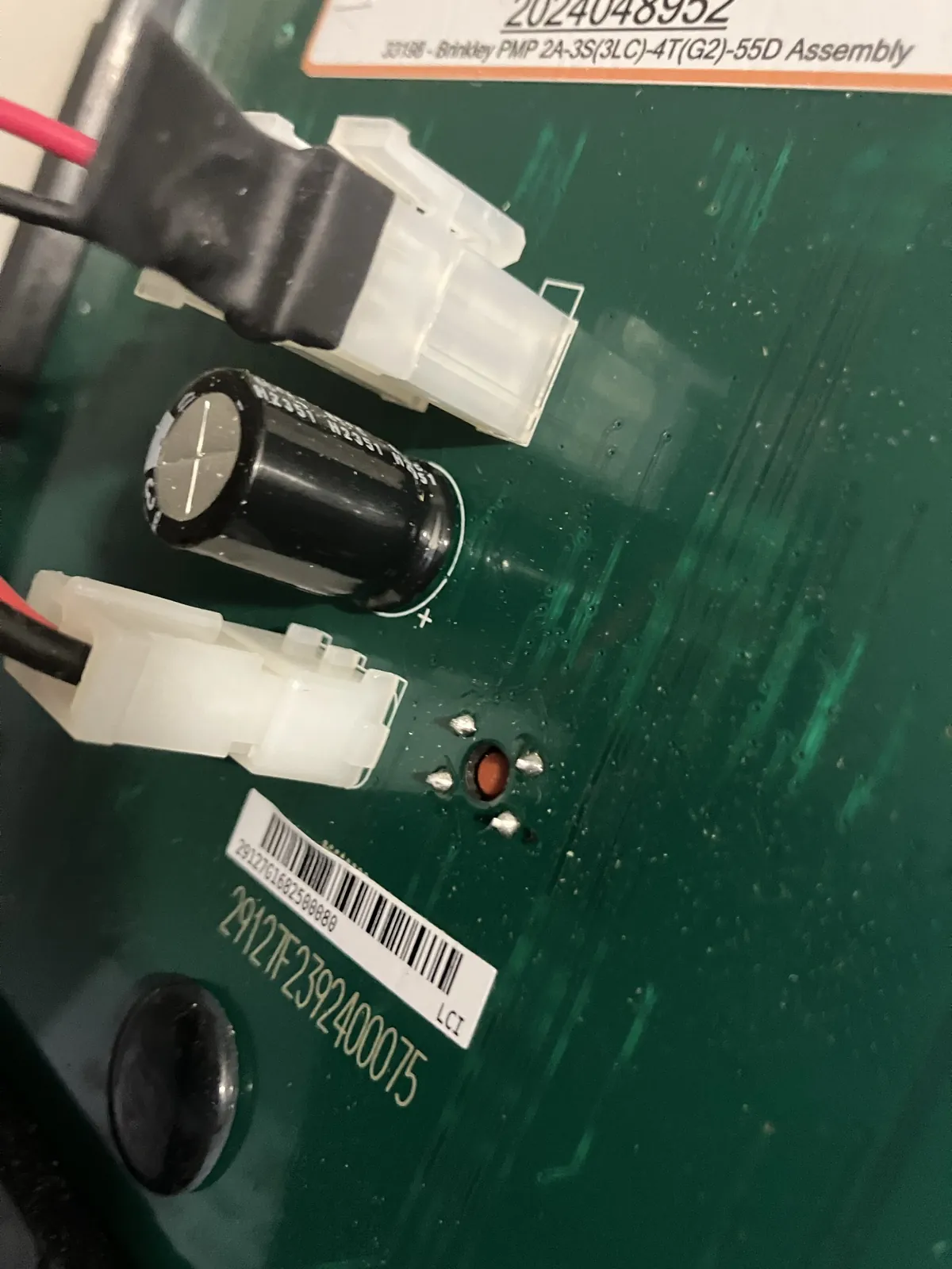Recessed red programming button on the rear circuit board of a Brinkley OneControl Premium Monitor Panel