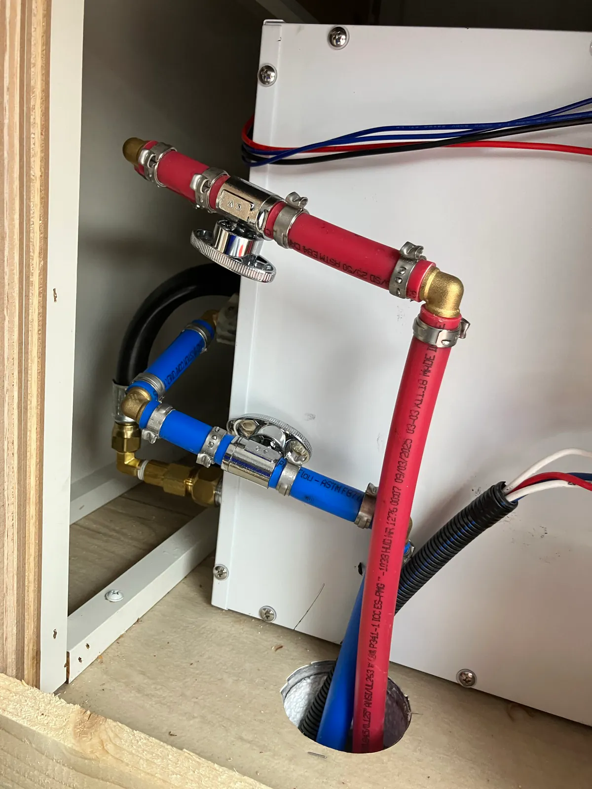 Hot and cold water lines, LP line and wiring reconnected behind a Brinkley Model Z tankless water heater