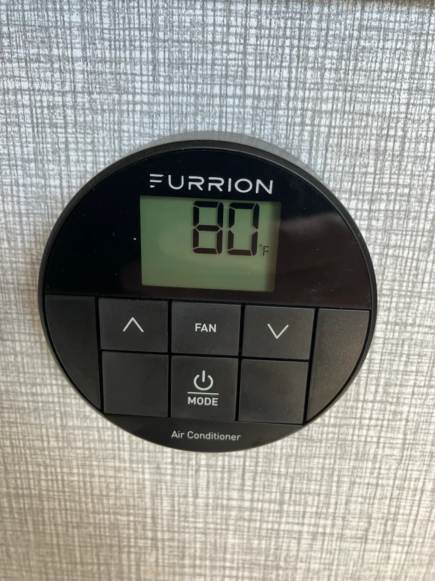 Round Furrion RV air conditioner thermostat displaying 80 degrees Fahrenheit